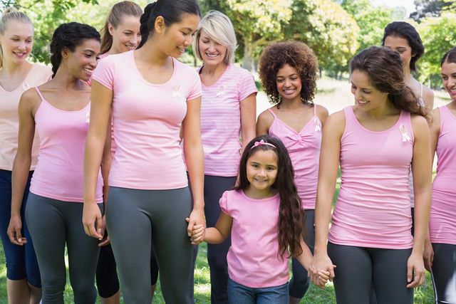 Women and girl in pink shirts smiling.