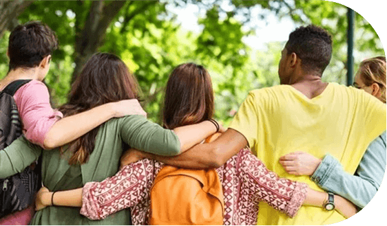 Group of friends embracing outdoors, backs facing.