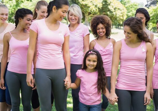 Women and girl in pink shirts smiling.